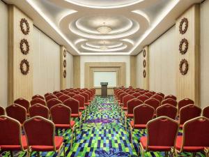 a conference room with red chairs and a podium at ibis Styles Cikarang in Cikarang +58 photos