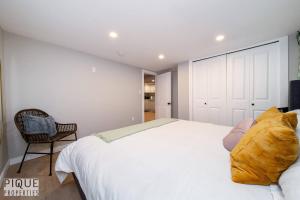 a bedroom with a large white bed and a chair at Modern Urban Escape -King Bed -Pet Friendly - Free Parking & Netflix - Fast Wi-Fi in Edmonton