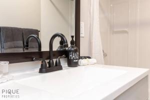 a bathroom counter with two sinks and a mirror at Modern Urban Escape -King Bed -Pet Friendly - Free Parking & Netflix - Fast Wi-Fi in Edmonton