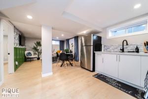a kitchen with white cabinets and a dining room at Modern Urban Escape -King Bed -Pet Friendly - Free Parking & Netflix - Fast Wi-Fi in Edmonton