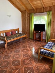 a living room with two beds and a flat screen tv at Pichares in Pichare