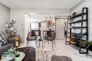 a living room with a couch and chairs and a kitchen at Park Life Retreat - King Bed - Pet Friendly - Sleeps 6 in Edmonton