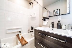 a bathroom with a tub and a sink and a bath tub at Park Life Retreat - King Bed - Pet Friendly - Sleeps 6 in Edmonton +36 photos