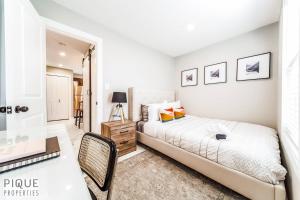 a white bedroom with a bed and a desk at Park Life Retreat - King Bed - Pet Friendly - Sleeps 6 in Edmonton