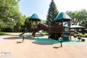 a child playing on a playground with a slide at Park Life Retreat - King Bed - Pet Friendly - Sleeps 6 in Edmonton