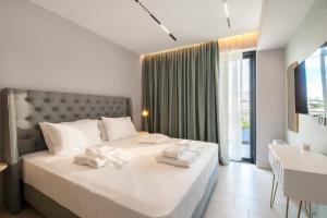 a bedroom with a large white bed with towels on it at PREVEZA VILLA center in Preveza +57 photos