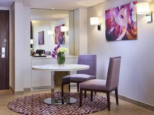 ein Esszimmer mit einem Tisch und zwei Stühlen in der Unterkunft Mercure Dubai Barsha Heights Hotel Suites And Apartments in Dubai