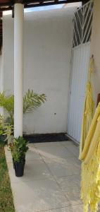 a porch with a swing and plants on it at Quarto 8km Aeroporto MCZ in Maceió