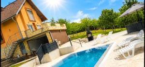a swimming pool in front of a house at Vikendica Sana in Sanski most