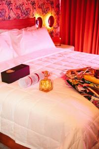 a white bed with a bottle and a box on it at Hotel Hilo - Room 101 in Louisville +14 photos