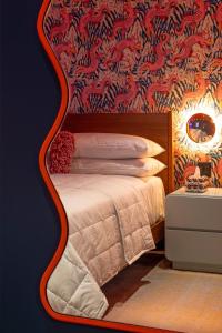 a bedroom with a bed with a red wall at Hotel Hilo - Room 101 in Louisville