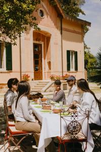 a group of people sitting at a table in front of a building at Tenuta Colavecchio Wine Relais in Putignano