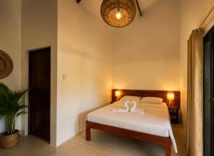 a bedroom with a bed with a white towel on it at Anaiah Garden Resort in Moalboal