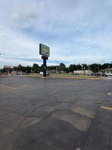 an empty parking lot with a sign in the middle at Regency Inn in Muskogee +3 photos
