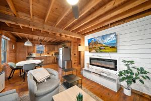 a living room with a large tv and a kitchen at Fox Trail Cabin in Boone