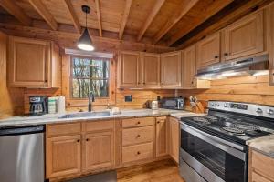 a kitchen with wooden cabinets and a stove top oven at Fox Trail Cabin in Boone +14 photos