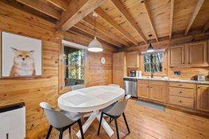 a dining room with a white table and a cat picture at Fox Trail Cabin in Boone