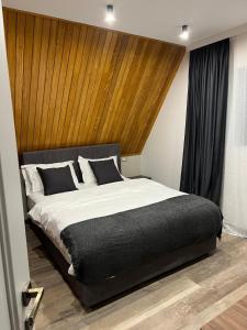 ein Schlafzimmer mit einem großen Bett mit hölzernem Kopfteil in der Unterkunft AVA Chalet in Comarnic