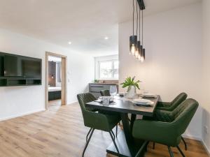 a dining room with a table and green chairs at Mosers Apartment in Reith im Alpbachtal