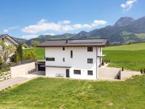a white house with mountains in the background at Mosers Apartment in Reith im Alpbachtal