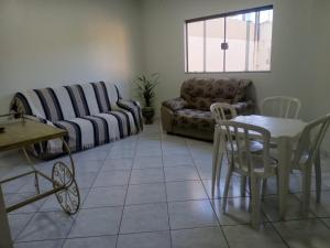 a living room with a couch and a table and chairs at Pousada Exclusiva in Rondonópolis