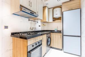 a kitchen with a stove top oven next to a refrigerator at Appart-Hôtel Luxury SuiteMar in M'diq