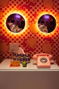 a counter with three mirrors and a clock on it at Hotel Hilo - Room 102 in Louisville