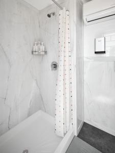 a bathroom with a shower with a white shower curtain at The Moon Hotel in Williams