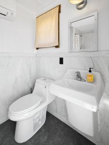 a white bathroom with a toilet and a sink at The Moon Hotel in Williams +7 photos
