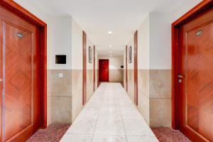 a hallway with wooden doors and a tile floor at Super Townhouse Oak Sector 39 Medanta in Gurgaon