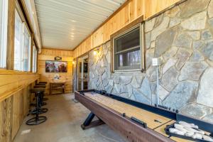 a stone wall in a room with a pool table at License to Chill Boone in Banner Elk