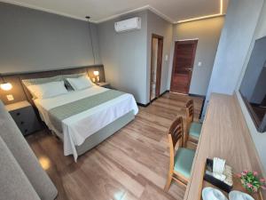 a bedroom with a bed and a table and chairs at NOVO HOTEL in Conceição do Coité
