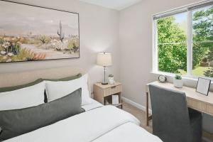 a bedroom with a bed and a desk and a window at Modern 3BR Davis Retreat in Davis