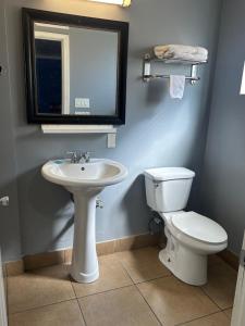 a bathroom with a sink and a toilet and a mirror at Driftwood Motel in Colton +10 photos