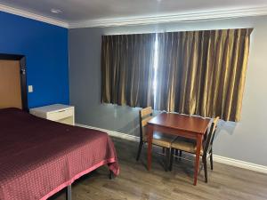 a bedroom with a desk and a bed and a table at Driftwood Motel in Colton