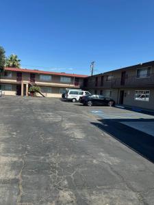 a parking lot with cars parked in front of a building at Driftwood Motel in Colton