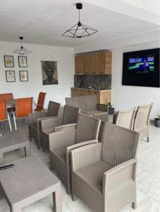 a waiting room with tables and chairs and a television at Rifugio Blu in Costinesti +9 photos