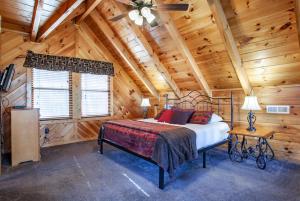 a bedroom with a bed in a wooden cabin at Whisk-A-Way - Hot Tub, Pool Table & Jacuzzi! in Abbeyville