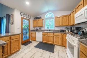 a kitchen with wooden cabinets and white appliances at Martinique in Redding +18 photos