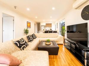 a living room with a couch and a flat screen tv at Spacious 4B Near Logan with Parking in Marsden