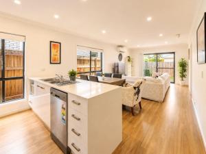 a kitchen and living room with a couch and a table at Spacious 4B Near Logan with Parking in Marsden