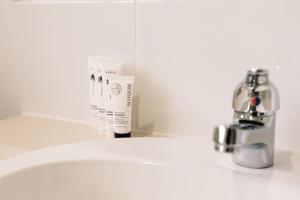 a bathroom sink with a bottle of soap next to it at Spacious 4B Near Logan with Parking in Marsden +12 photos