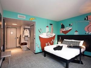 a bedroom with a bed and a wall with a mural at ibis Styles Genève Carouge in Geneva