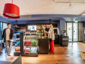 two women standing at a cash register in a store at ibis Styles Haarlem City in Haarlem