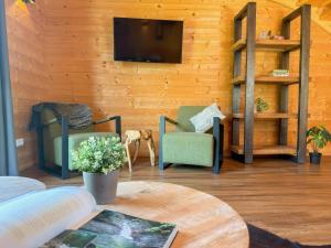 a living room with two chairs and a tv on a wall at Rattendorf 3A in Rattendorf