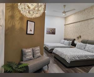 a room with two beds and a couch and a chandelier at Rooms only @KKB in Kuala Kubu Bharu +2 photos
