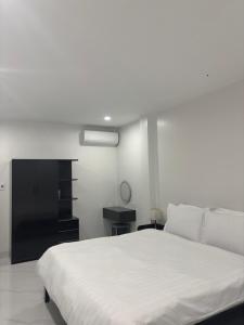 a bedroom with a white bed and a black cabinet at A T Homestay in Thôn Dương Xuân Hạ +18 photos