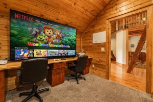 a computer desk with a large screen in a room at North View Lodge High Country in Banner Elk