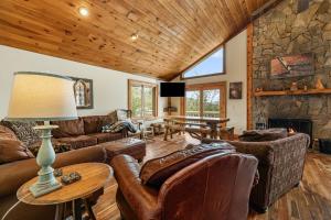 a living room with leather furniture and a stone fireplace at North View Lodge High Country in Banner Elk