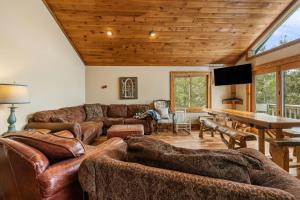 a living room with leather furniture and a wooden ceiling at North View Lodge High Country in Banner Elk